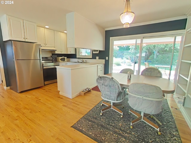 kitchen with sink, light hardwood / wood-style flooring, appliances with stainless steel finishes, white cabinetry, and decorative light fixtures