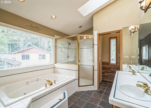 bathroom with tile patterned flooring, vanity, lofted ceiling with skylight, and independent shower and bath