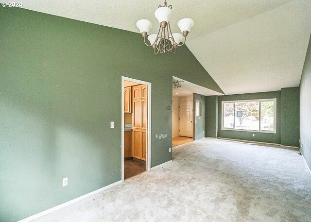 carpeted spare room featuring a chandelier and lofted ceiling