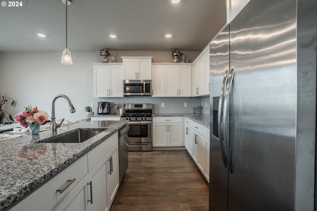 kitchen with dark wood-type flooring, sink, pendant lighting, white cabinetry, and appliances with stainless steel finishes