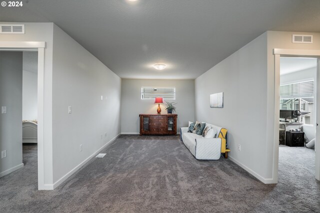 sitting room featuring dark carpet