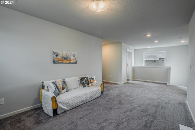 living room with a textured ceiling and carpet flooring