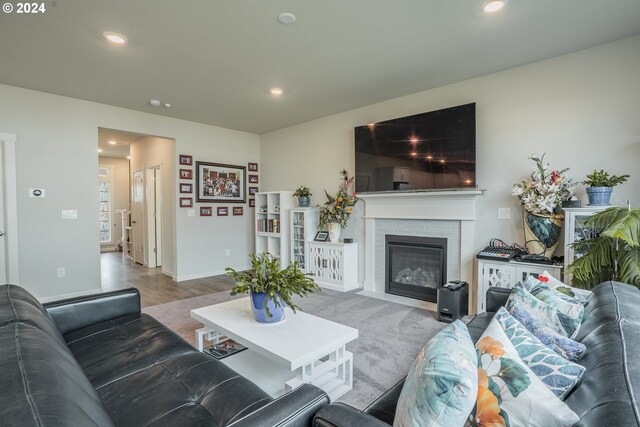 living room featuring a brick fireplace and wood-type flooring