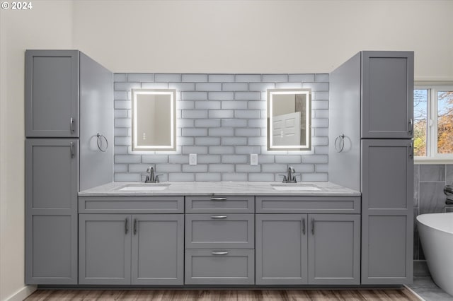 bathroom featuring vanity, hardwood / wood-style floors, and a tub