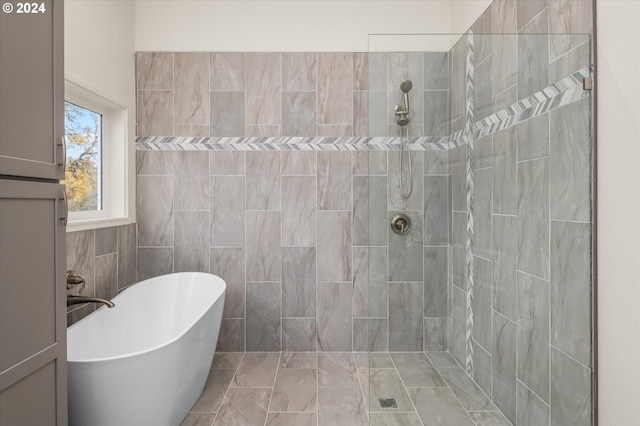 bathroom featuring shower with separate bathtub and tile walls