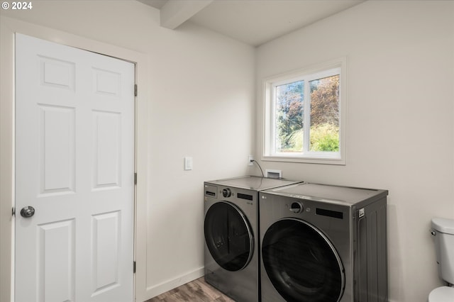 laundry area featuring washing machine and clothes dryer and light hardwood / wood-style floors