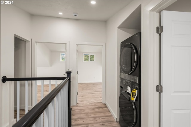 corridor featuring stacked washer / dryer and light wood-type flooring