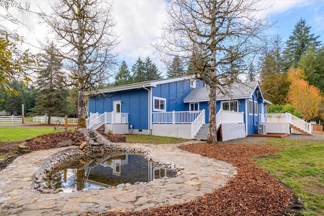 rear view of property featuring a lawn and a porch