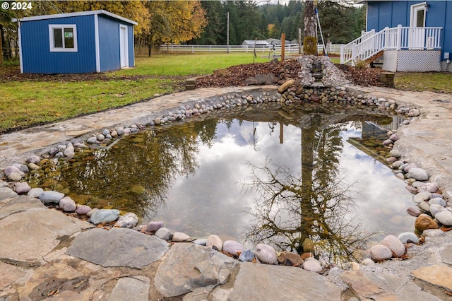 view of swimming pool featuring an outdoor structure and a yard