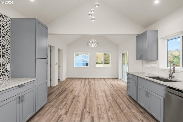 kitchen with white dishwasher, sink, gray cabinetry, and plenty of natural light