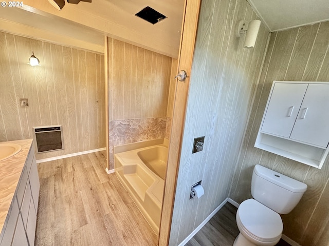 bathroom featuring wooden walls, hardwood / wood-style flooring, toilet, and vanity