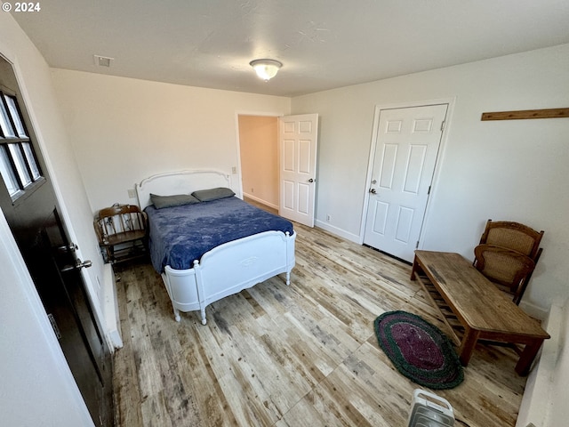 bedroom featuring light wood-style floors and baseboards