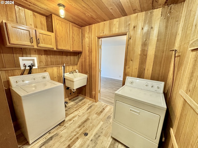 laundry room with cabinet space, independent washer and dryer, wooden walls, light wood finished floors, and wooden ceiling