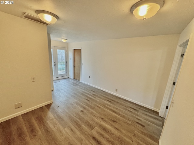 empty room featuring hardwood / wood-style floors and french doors