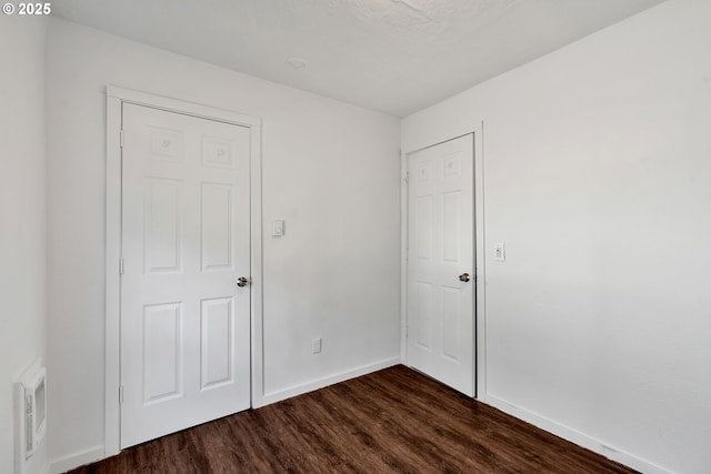 unfurnished room featuring dark wood-type flooring