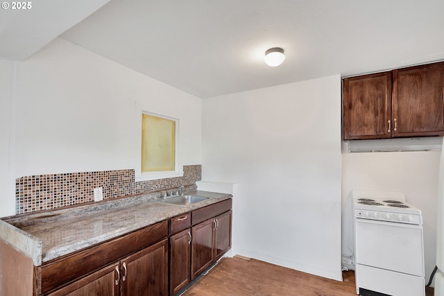 kitchen featuring sink, tasteful backsplash, dark brown cabinets, electric stove, and light hardwood / wood-style floors