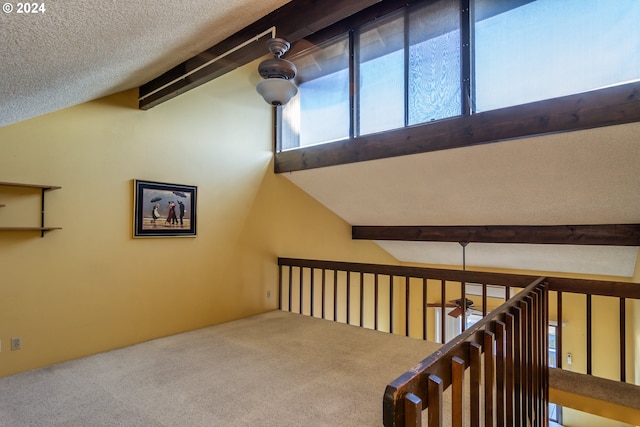 interior space featuring lofted ceiling with beams, carpet, and a textured ceiling