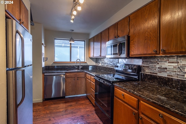 kitchen with decorative light fixtures, sink, decorative backsplash, dark hardwood / wood-style floors, and appliances with stainless steel finishes