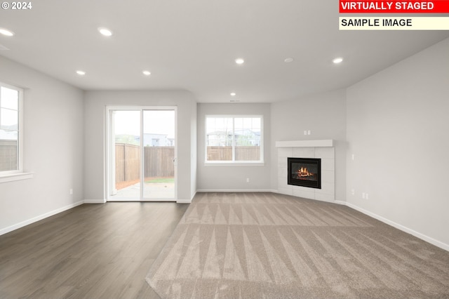 unfurnished living room featuring a fireplace, baseboards, wood finished floors, and recessed lighting