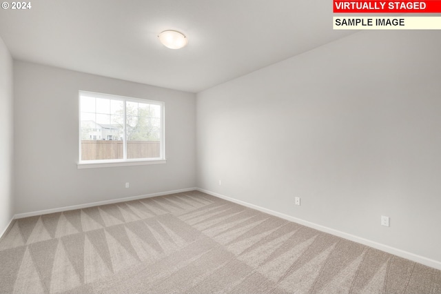 carpeted spare room featuring baseboards