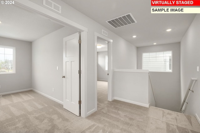 unfurnished room featuring carpet, visible vents, and baseboards