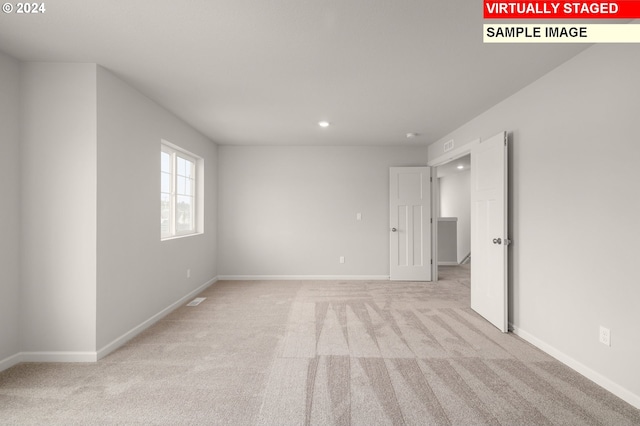 unfurnished room featuring recessed lighting, light carpet, and baseboards