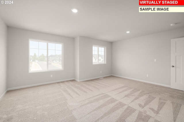 empty room featuring recessed lighting, light carpet, and baseboards