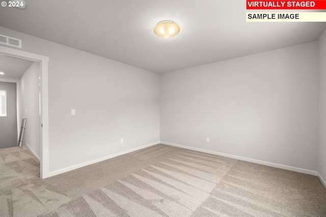 spare room with carpet flooring, visible vents, and baseboards