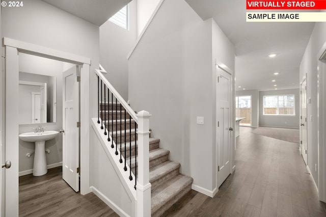 staircase featuring baseboards, wood finished floors, and recessed lighting