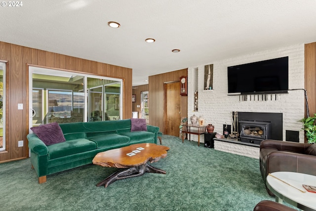 living room featuring wood walls, a fireplace, and carpet