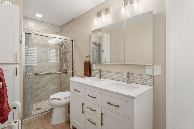 bathroom with vanity, hardwood / wood-style floors, walk in shower, toilet, and decorative backsplash