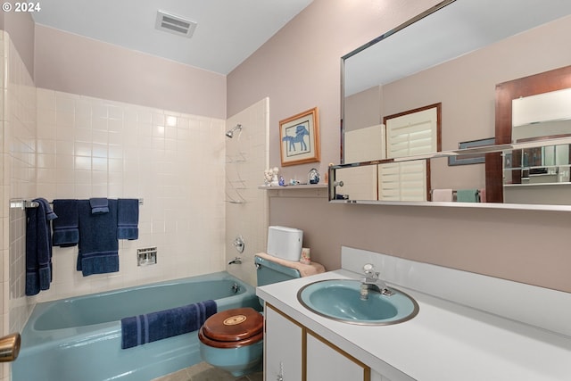 full bathroom featuring tiled shower / bath combo, vanity, and toilet