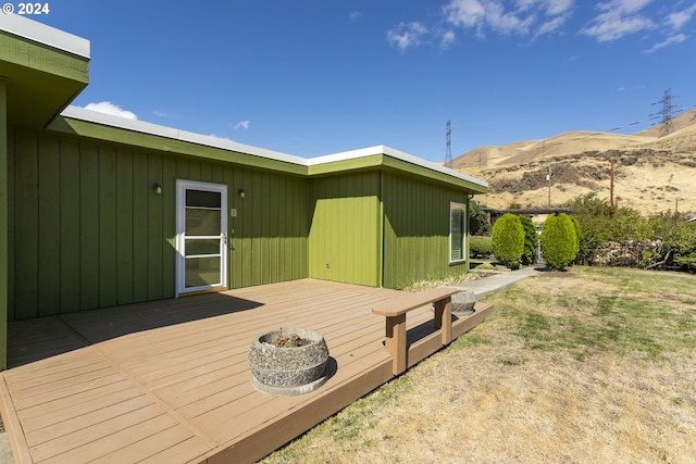 wooden deck with a lawn and a mountain view