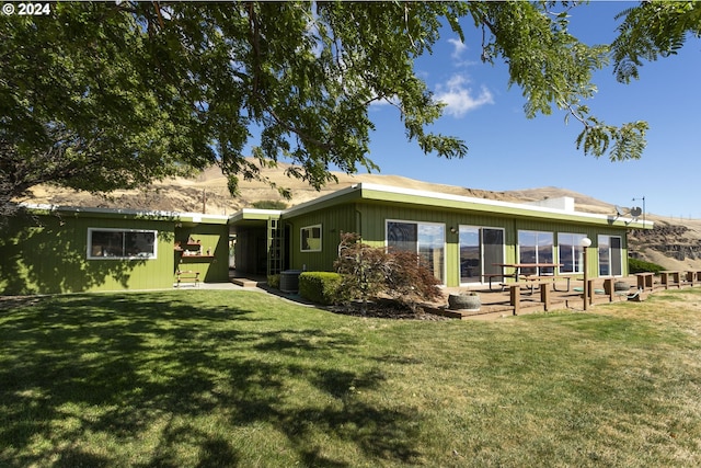 back of property with central air condition unit, a lawn, and a patio area