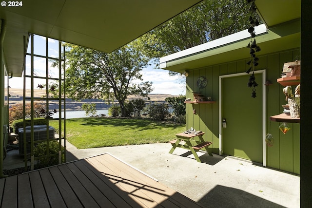 view of patio featuring cooling unit and a deck with water view