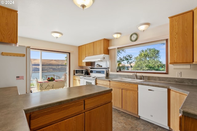 kitchen with sink, white appliances, and a water view