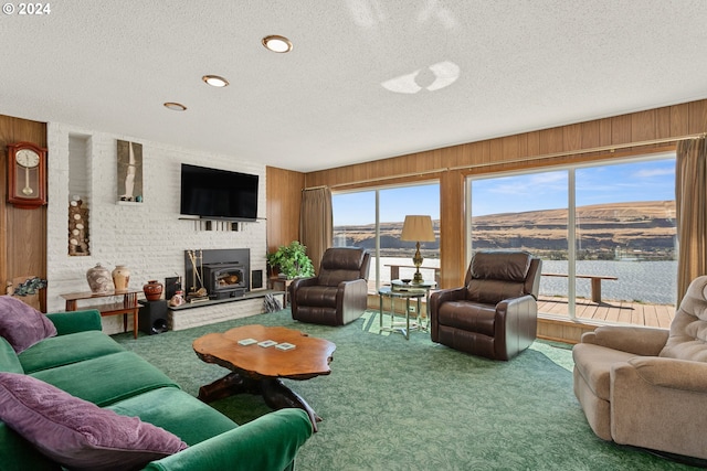 living room with wood walls, a textured ceiling, and carpet floors