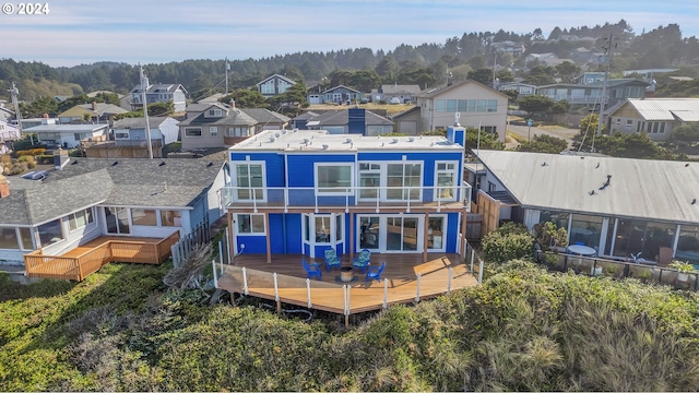 rear view of property with a deck and a balcony