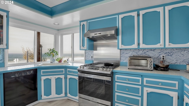 kitchen featuring black dishwasher, light hardwood / wood-style floors, stainless steel stove, wall chimney range hood, and blue cabinetry