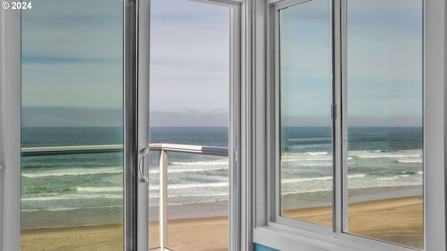 interior space featuring plenty of natural light, a water view, and a view of the beach