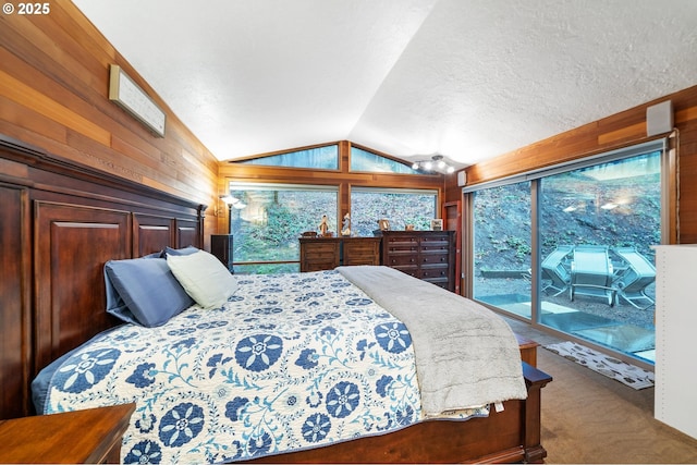 carpeted bedroom featuring access to exterior, wooden walls, and vaulted ceiling