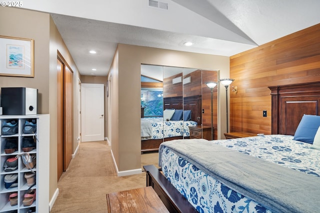 carpeted bedroom with wood walls and lofted ceiling