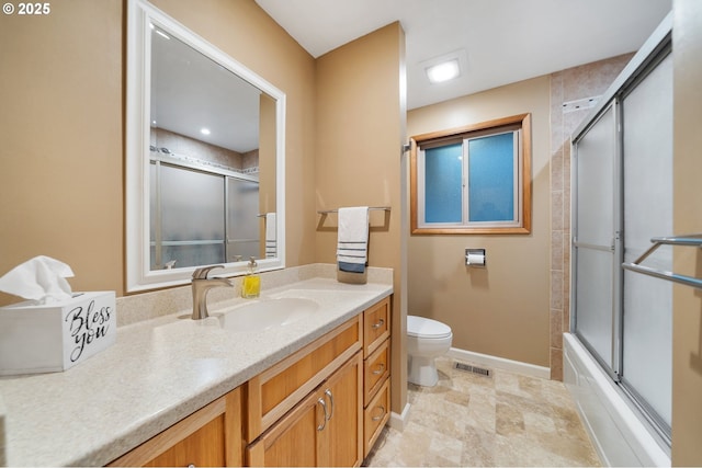 full bathroom with vanity, toilet, and bath / shower combo with glass door