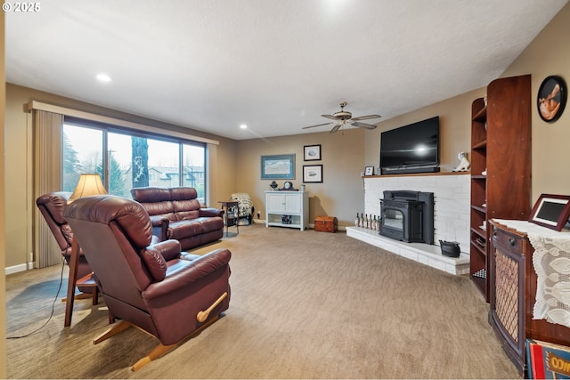 living room with a wood stove, ceiling fan, and light carpet