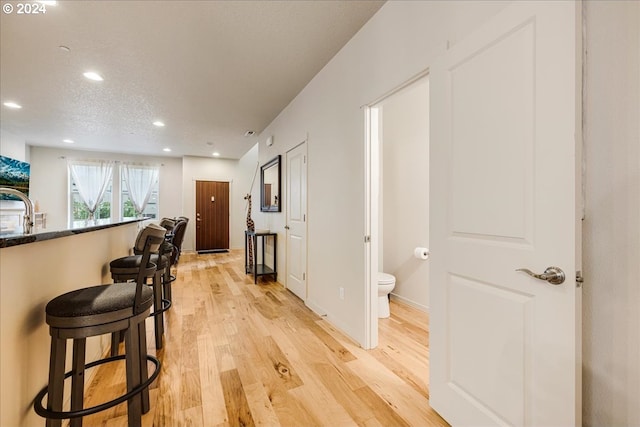 interior space featuring a textured ceiling, light wood-type flooring, and sink