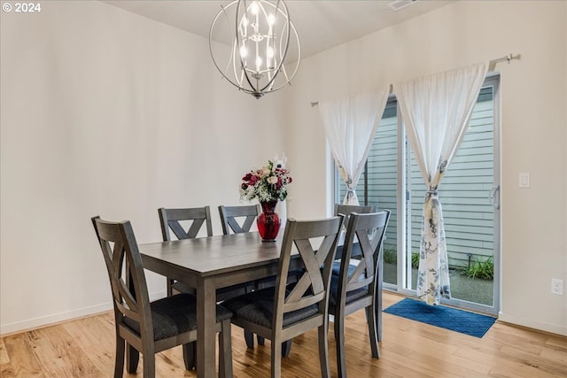 dining space featuring light hardwood / wood-style flooring and an inviting chandelier