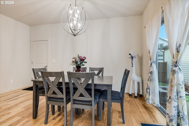 dining room with light hardwood / wood-style flooring and a chandelier