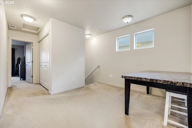 unfurnished office with a textured ceiling and light colored carpet