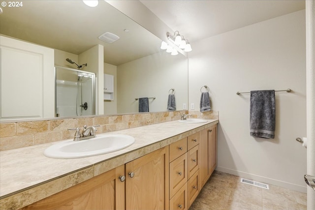 bathroom featuring tasteful backsplash, vanity, and an enclosed shower