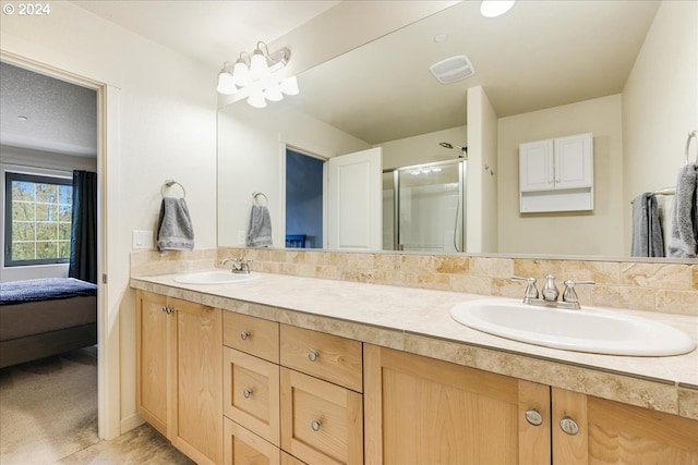 bathroom featuring a shower with door, vanity, and tile patterned flooring